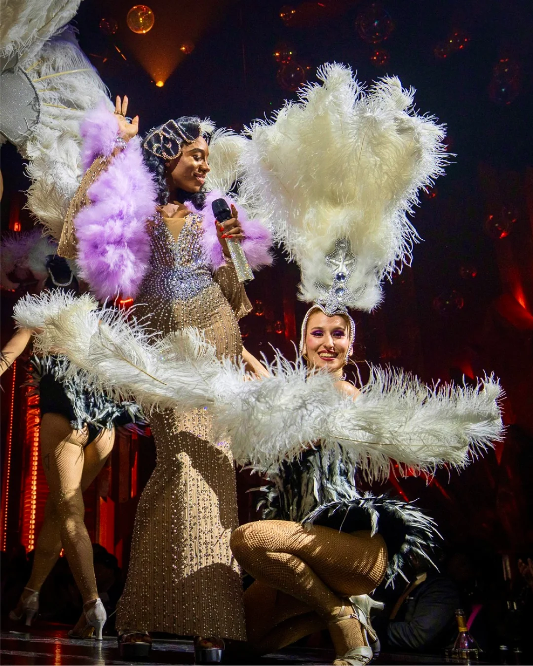 Circensia cabaret performers onstage in feathered costumes