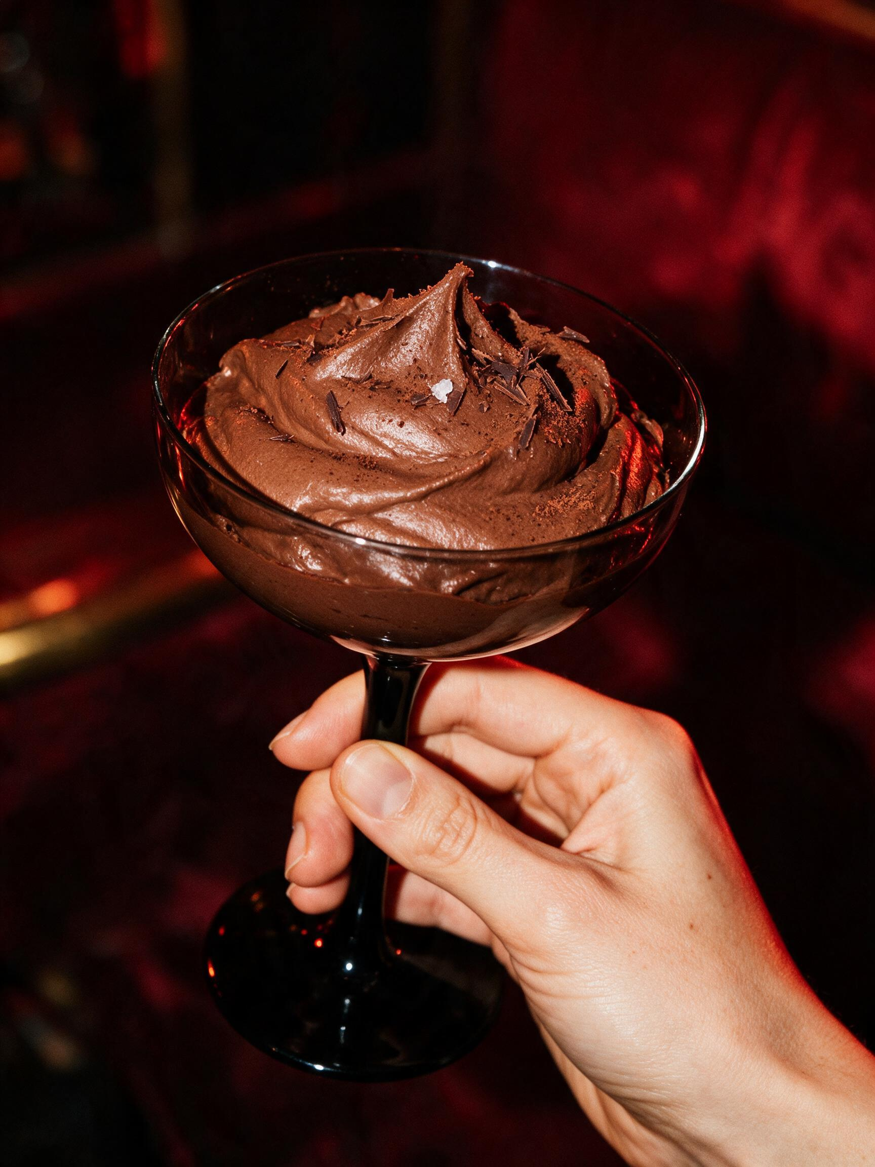 Chocolate mousse in a black-stem coupe, dusted with cocoa and sea salt