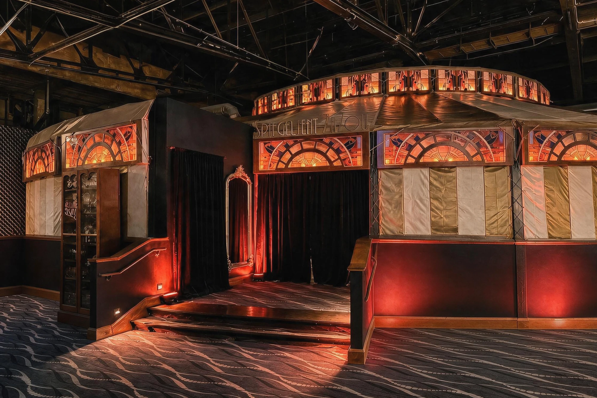 Spiegeltent entrance with gold and white stripes, stained-glass arches, velvet curtains, and a SPIEGELTENT sign